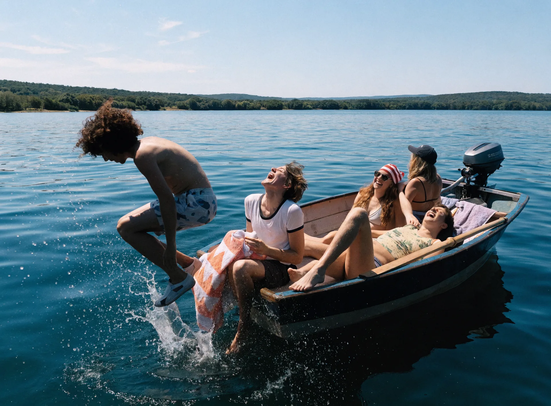 Freunde genießen einen Sommertag auf dem See im kleinen Boot